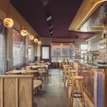 Gezellig café-interieur met houten tafels, bar en harde vloeroppervlakken
