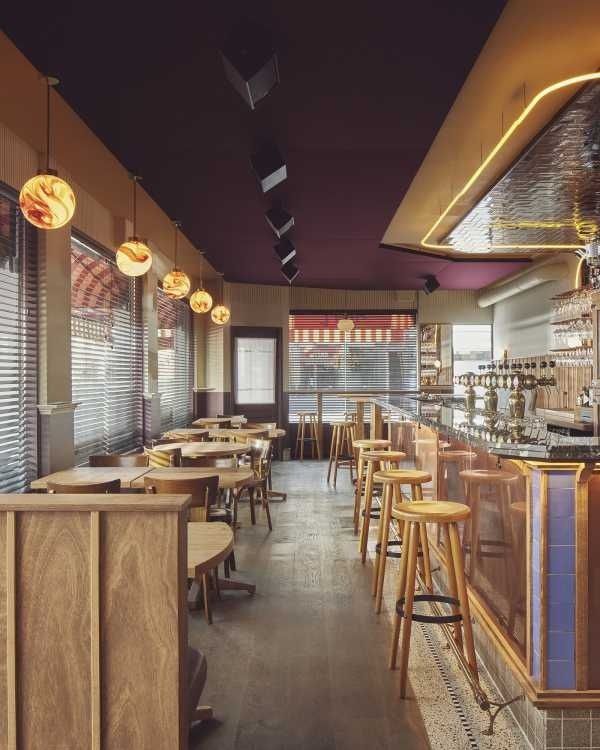 Gezellig café-interieur met houten tafels, bar en harde vloeroppervlakken
