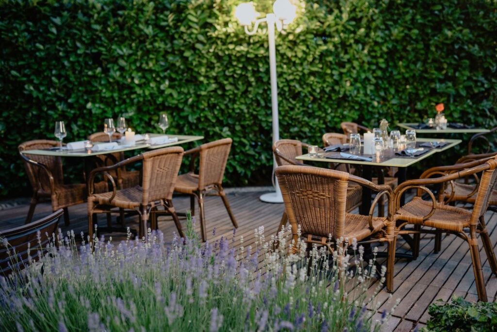 Verzorgd restaurantterras met gedekte tafels en rieten stoelen