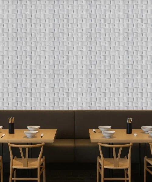 Restaurantbank met houten tafels voor een witte reliëfwand