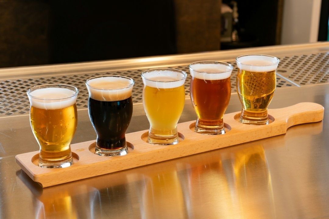 Vijf glazen speciaalbier op een houten proefplank aan de bar