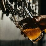 Barman tapt een goudkleurig speciaalbier in een schuin gehouden glas