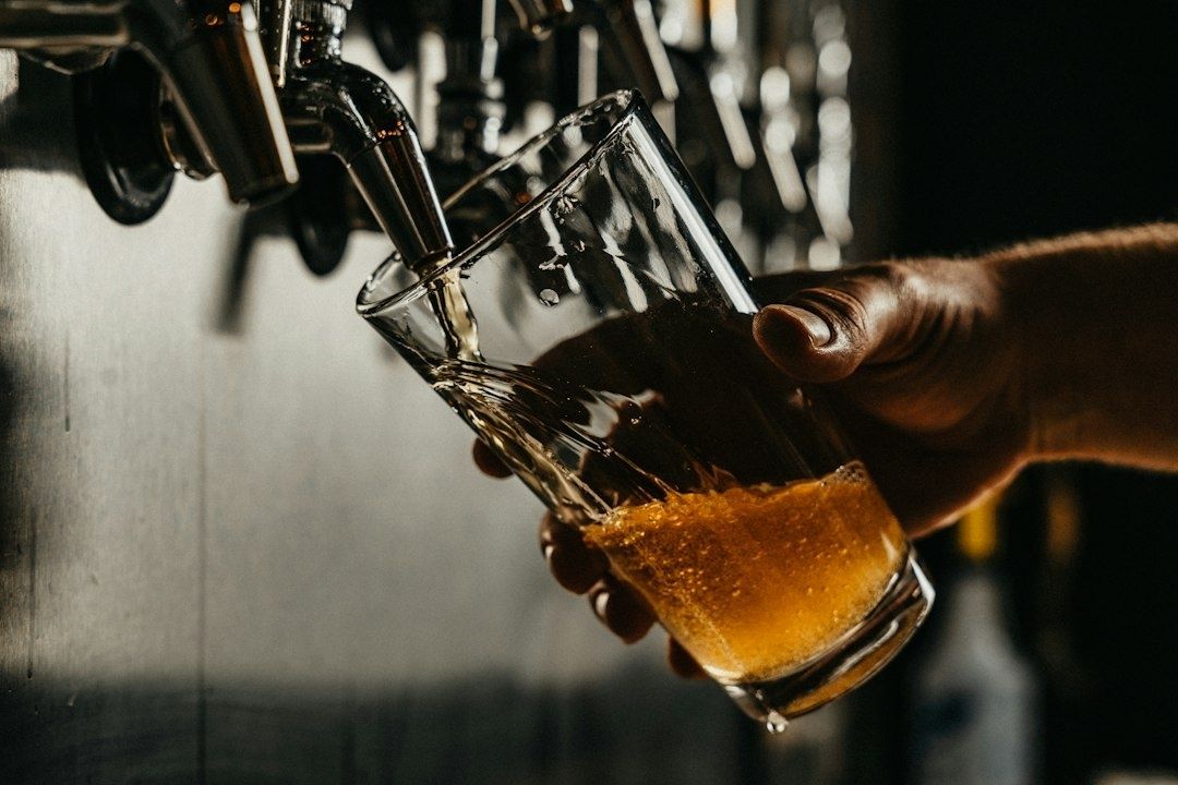 Barman tapt een goudkleurig speciaalbier in een schuin gehouden glas